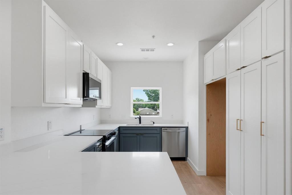 508 South O Connor Road Irving, TX 75060 - Photo 2 of 21 Modern kitchen featuring white shaker cabinetry, light-toned countertops, a stainless steel dishwasher, an integrated microwave, and wood-finish flooring