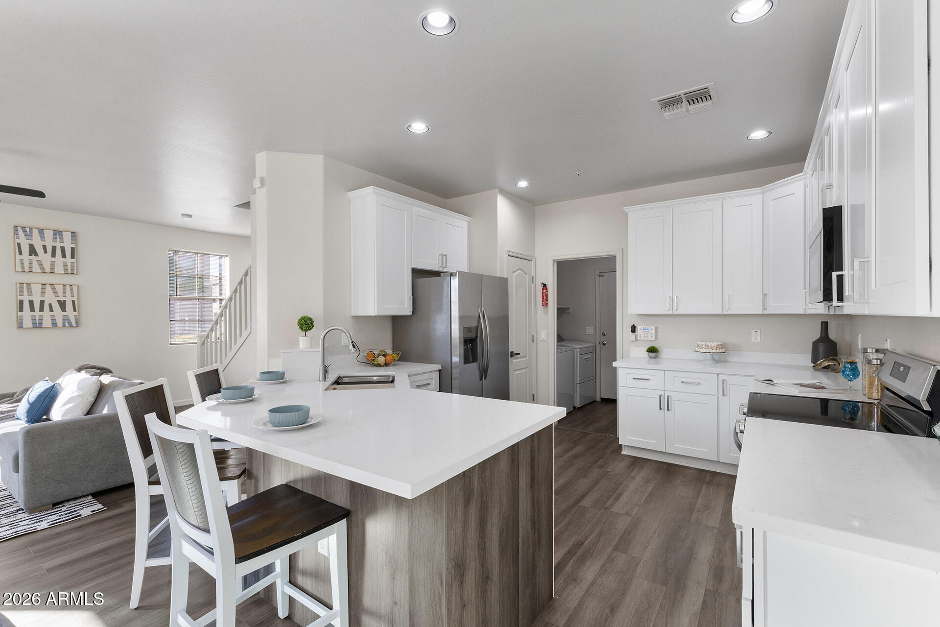 a kitchen with a dining table cabinets appliances and wooden floor