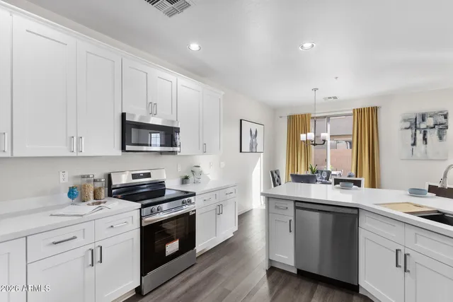 a kitchen with stainless steel appliances white cabinets sink and stove