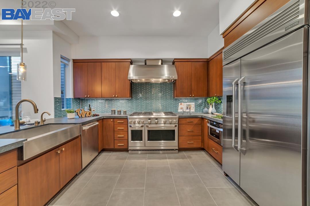 a large kitchen with stainless steel appliances granite countertop a stove and a sink