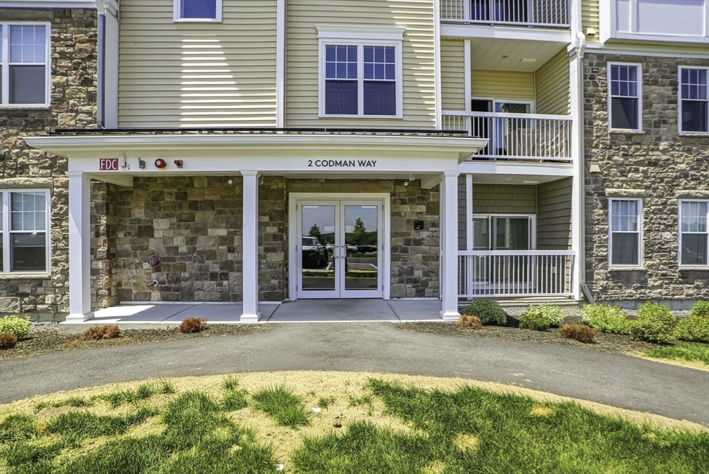 2 Codman Way, Unit 2203 Westborough, MA 01581 - Photo 35 of 36 a front view of a building with a garden and entryway