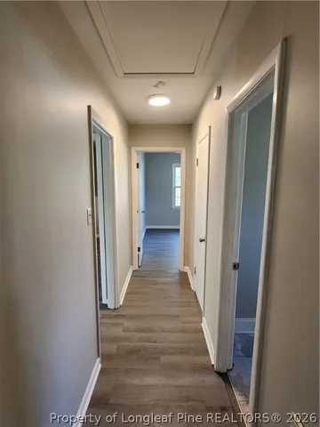 a view of a hallway with wooden floor