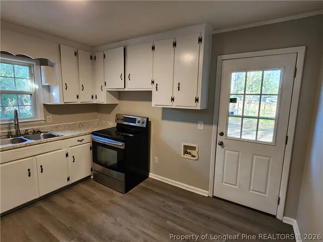 a kitchen with granite countertop white cabinets and stainless steel appliances