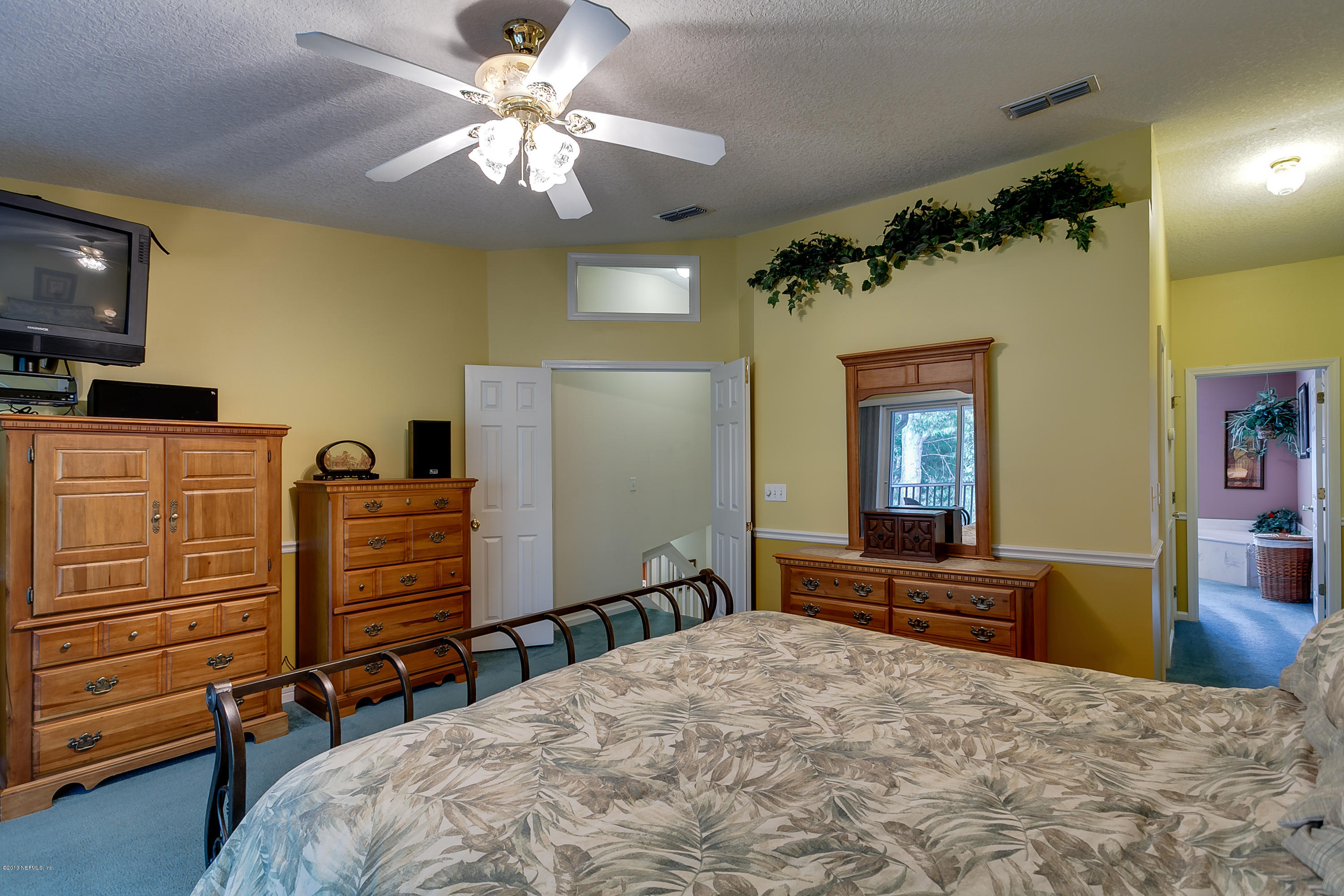 3105 Ravines Road Middleburg, FL 32068 - Photo 19 of 32 a bedroom with a bed and a chandelier