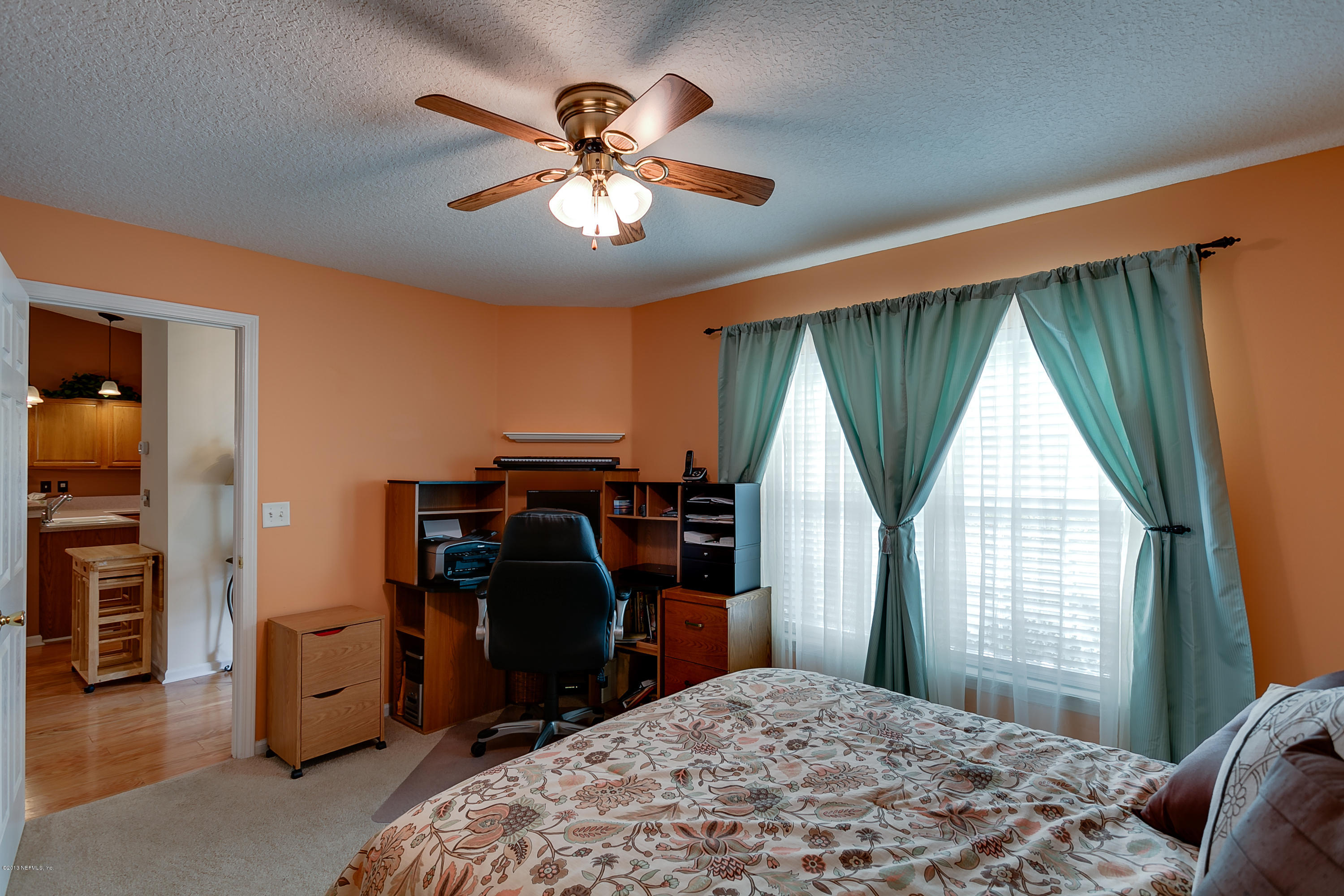 3105 Ravines Road Middleburg, FL 32068 - Photo 27 of 32 a bedroom with a bed and a chandelier
