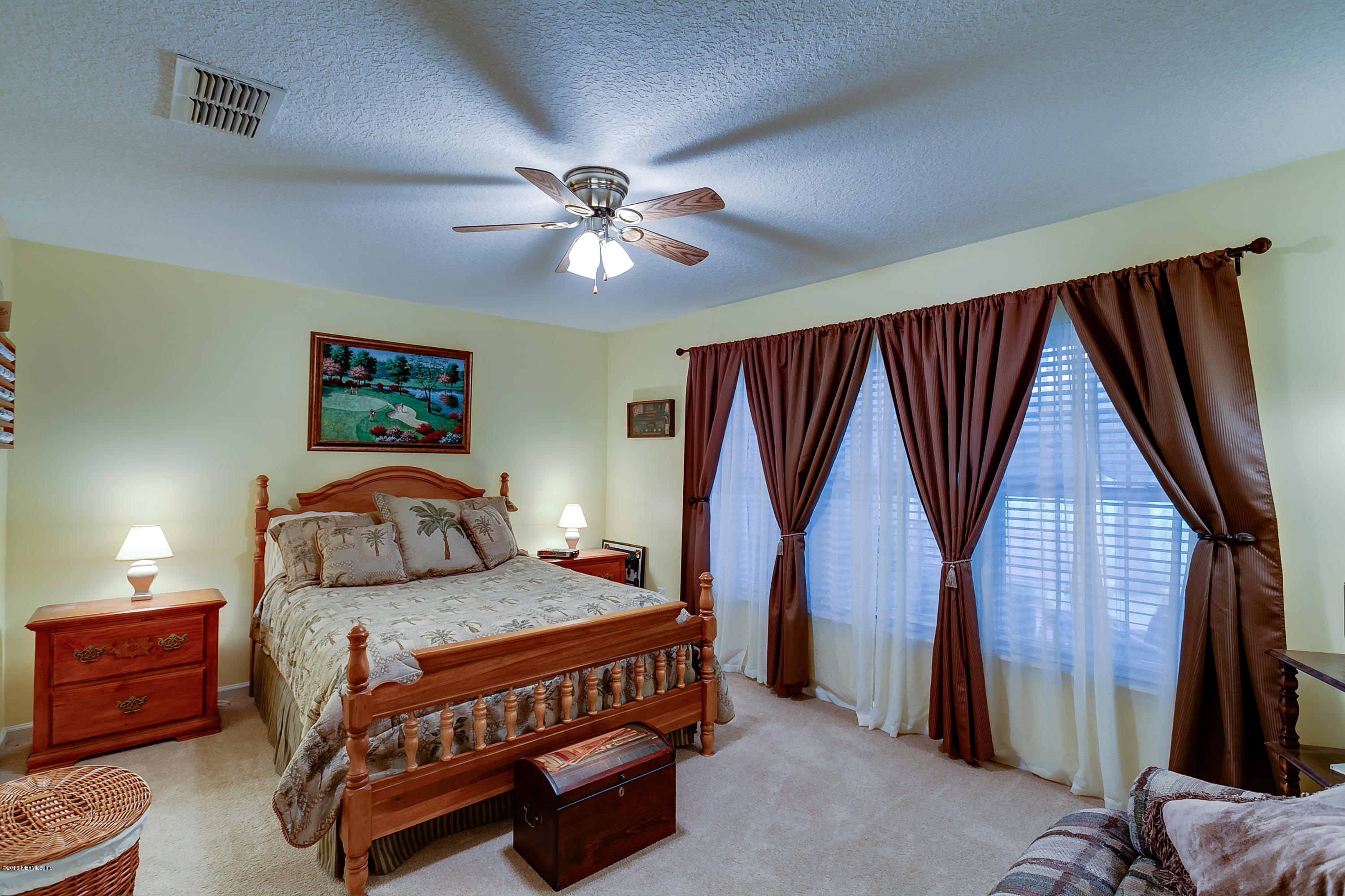 3105 Ravines Road Middleburg, FL 32068 - Photo 28 of 32 a bedroom with a bed chandelier and a window