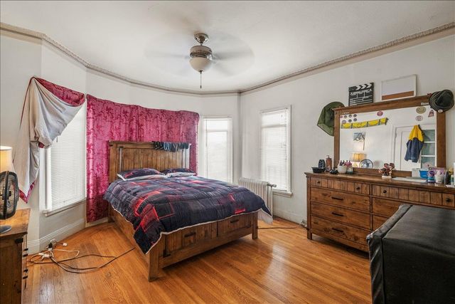 a bedroom with a bed and a mirror on dresser
