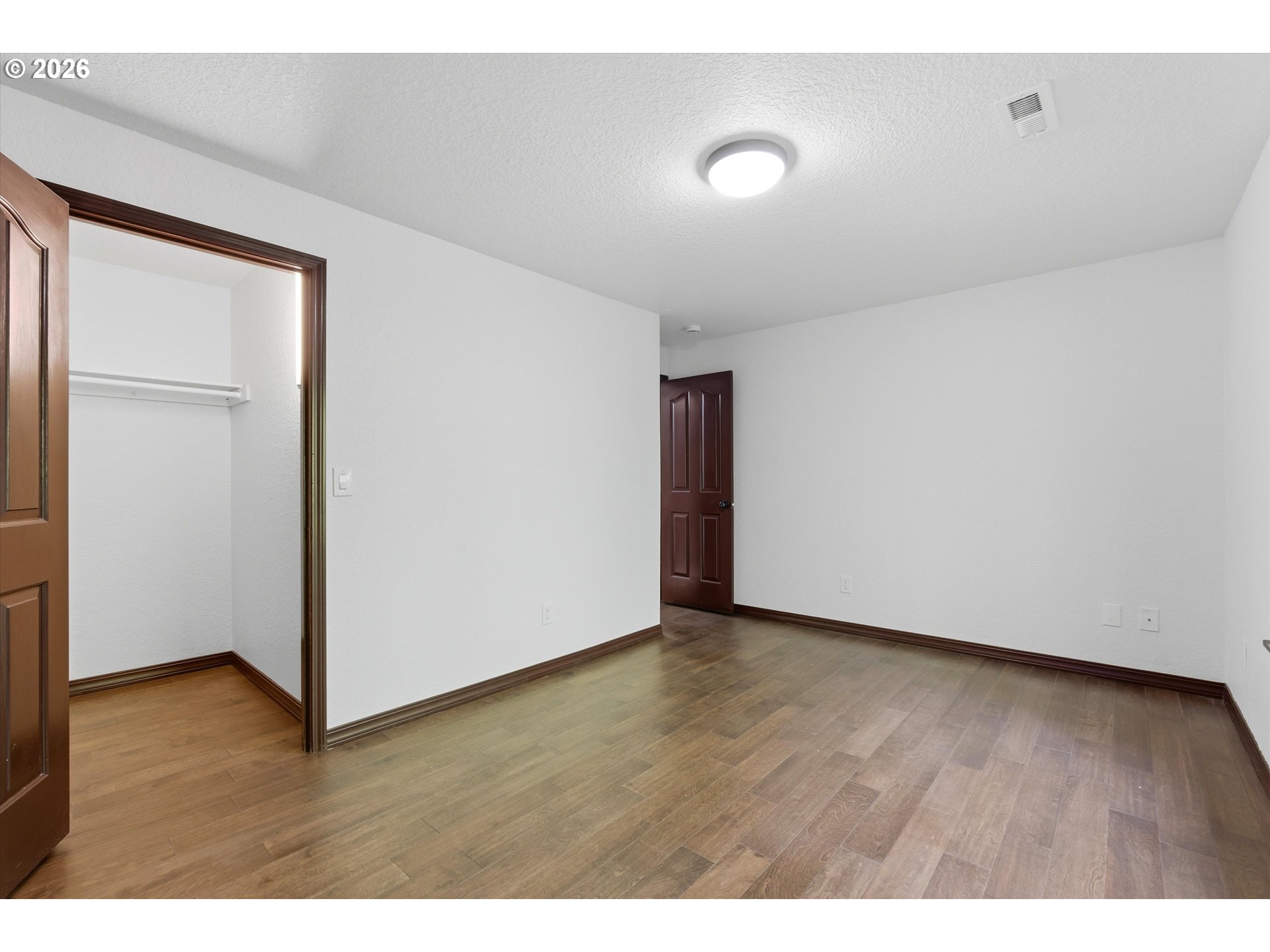 7236 Southeast 133rd Place Portland, OR 97236 - Photo 37 of 42 a view of an empty room with wooden floor and closet
