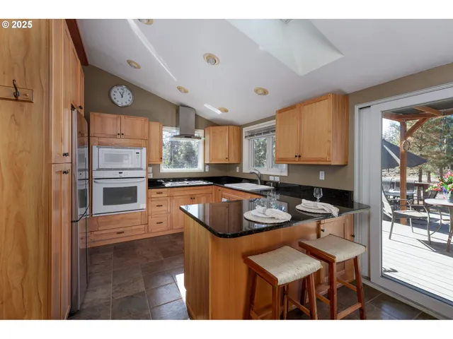a kitchen with stainless steel appliances granite countertop a sink refrigerator and cabinets