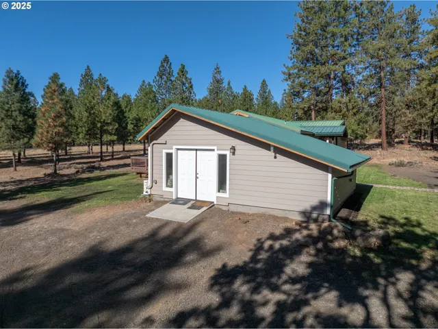a view of a house with backyard and trees