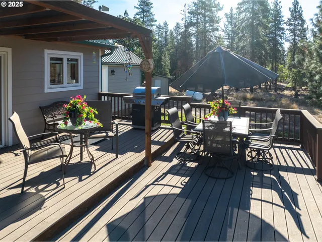 a view of a roof deck with table and chairs under an umbrella with wooden floor