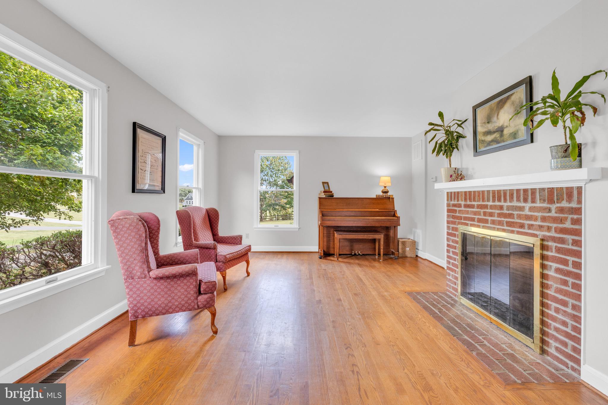8729 Green Road Warrenton, VA 20187 - Photo 11 of 42 a living room with furniture a fireplace and a floor to ceiling window
