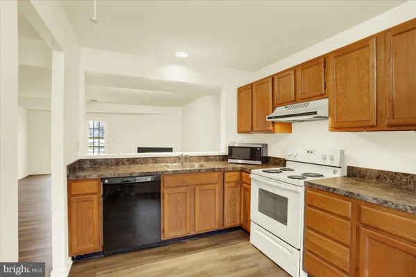a kitchen with a stove sink and cabinets