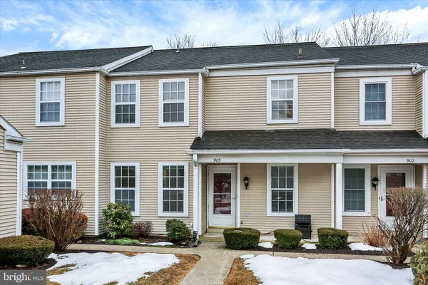 front view of a brick house with potted plants