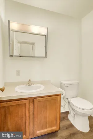a bathroom with a granite countertop sink and a toilet