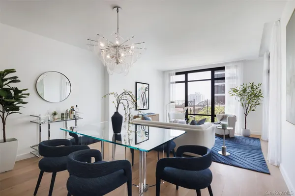 a living room with furniture chandelier and a large window