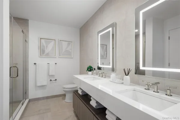 a bathroom with a double vanity sink toilet and shower