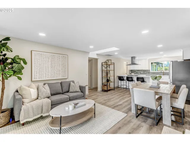 a living room with furniture and a dining table with kitchen view