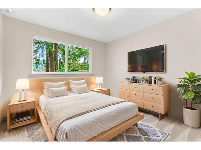 a bedroom with a large bed and a flat tv screen on dresser