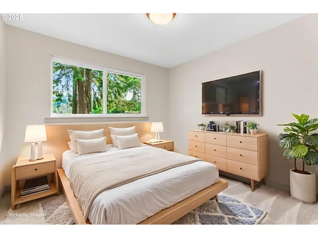 a bedroom with a large bed and a flat tv screen on dresser