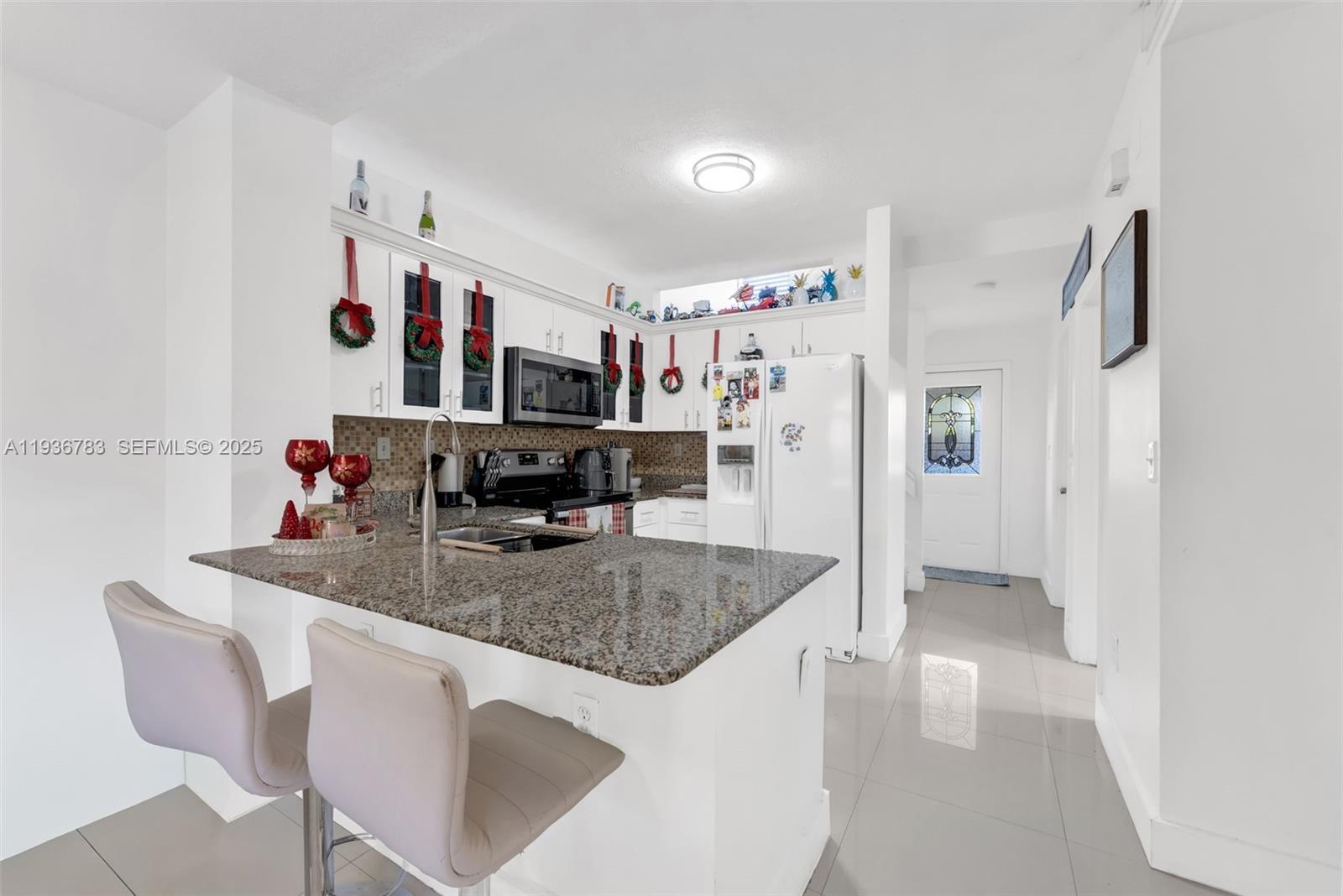 3725 Southwest 153rd Court Miami, FL 33185 - Photo 7 of 22 a kitchen with stainless steel appliances granite countertop a sink refrigerator and microwave
