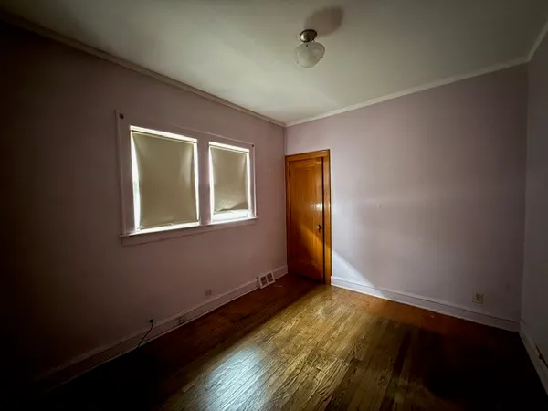 a view of room with window and wooden floor