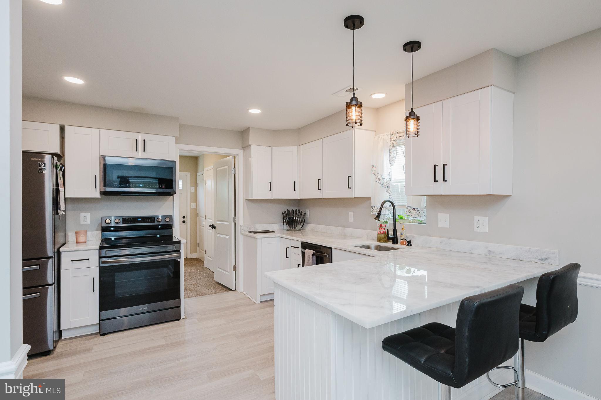 4 Right Aileron Baltimore, MD 21220 - Photo 7 of 30 a kitchen with stainless steel appliances granite countertop a sink a stove a refrigerator and island with wooden floor