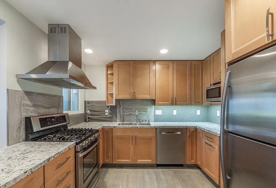 4927 Indian Wood Road Culver City, CA 90230 - Photo 18 of 20 a kitchen with kitchen island granite countertop a sink stainless steel appliances and cabinets