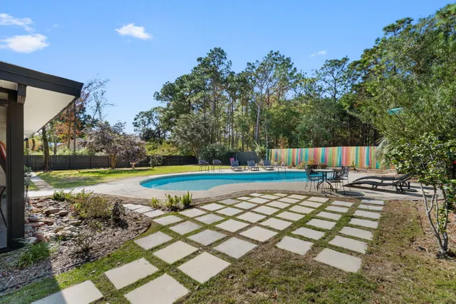 a swimming pool with outdoor seating and yard