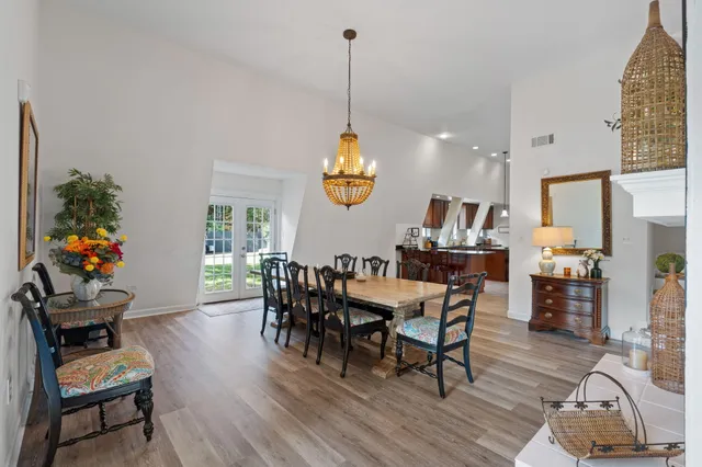 a dining room filled chandelier and wooden floor