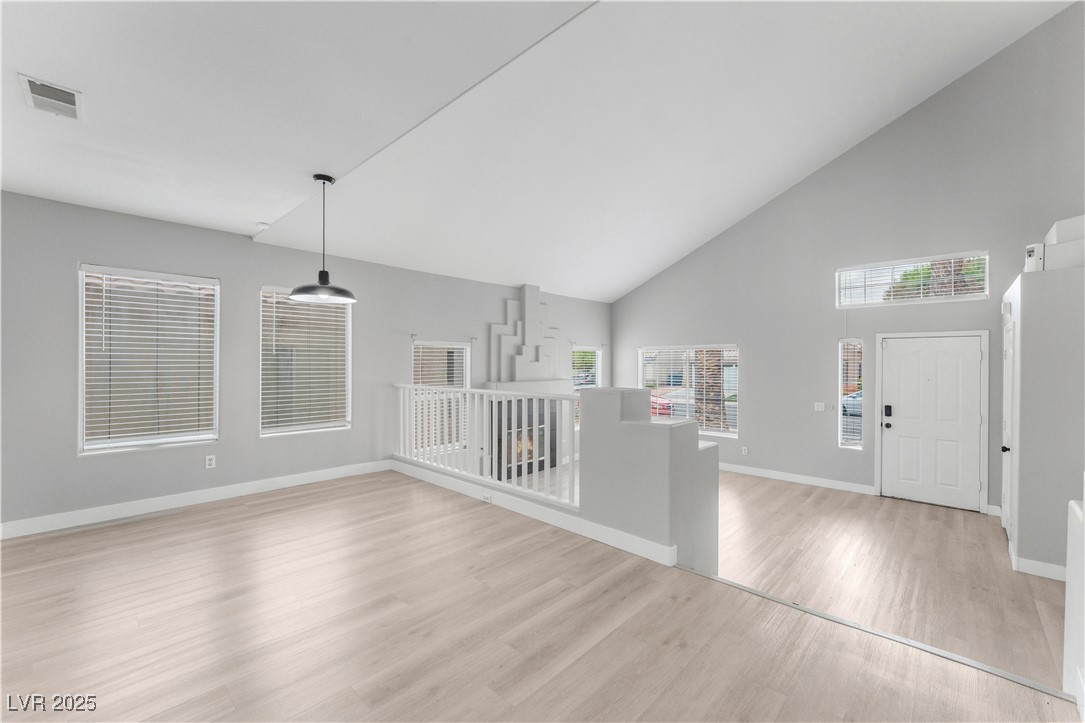 3695 Funston Way Las Vegas, NV 89129 - Photo 10 of 43 Unfurnished living room featuring high vaulted ceiling and light wood-style flooring