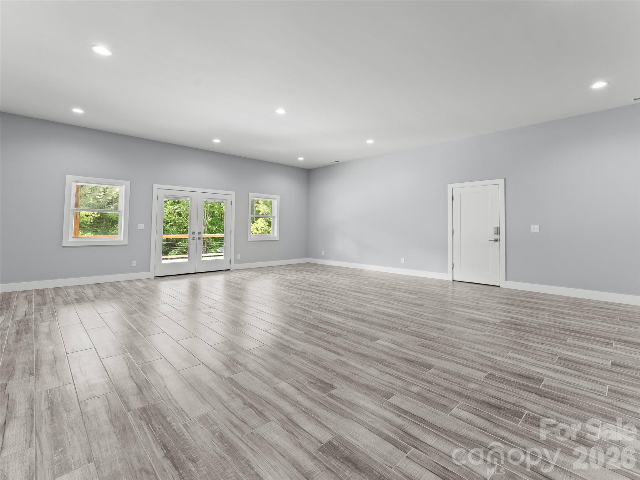 123 Israel Road Candler, NC 28715 - Photo 32 of 44 an empty room with wooden floor and windows