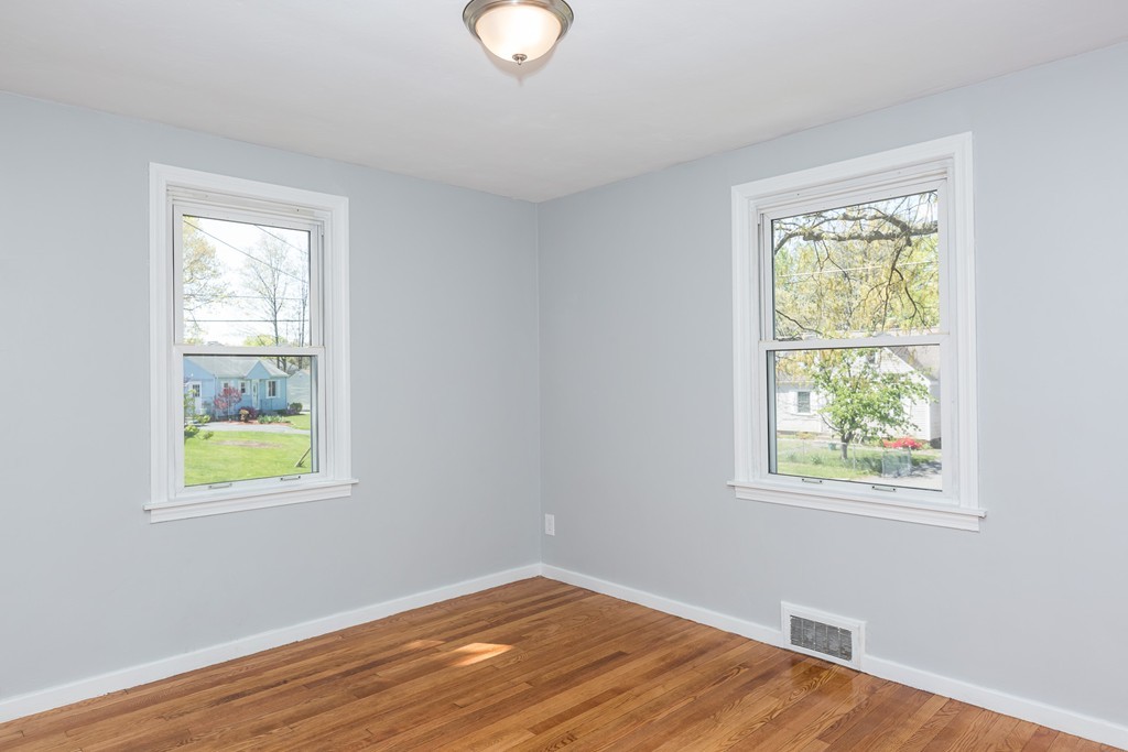 219 Cooper Street Springfield, MA 01108 - Photo 16 of 29 a view of an empty room with wooden floor and a window