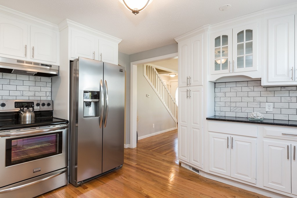 219 Cooper Street Springfield, MA 01108 - Photo 2 of 29 a kitchen with granite countertop a refrigerator and a stove top oven