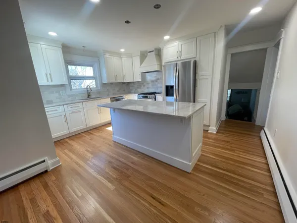 a view of kitchen with sink and refrigerator