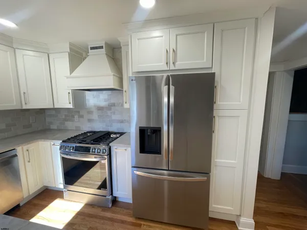 a kitchen with a refrigerator stove and wooden cabinets