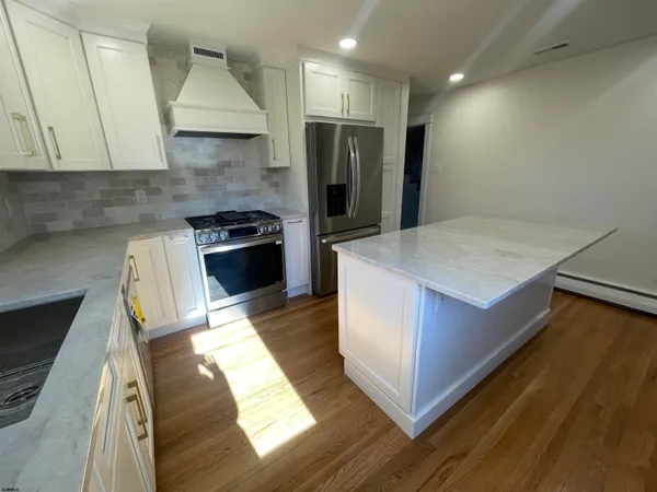 a kitchen with kitchen island sink stove and refrigerator