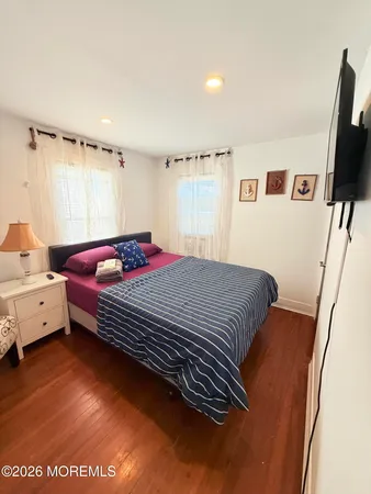 a bedroom with a bed and a flat tv screen on the dresser