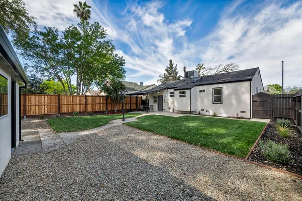a view of backyard with wooden fence and a large tree