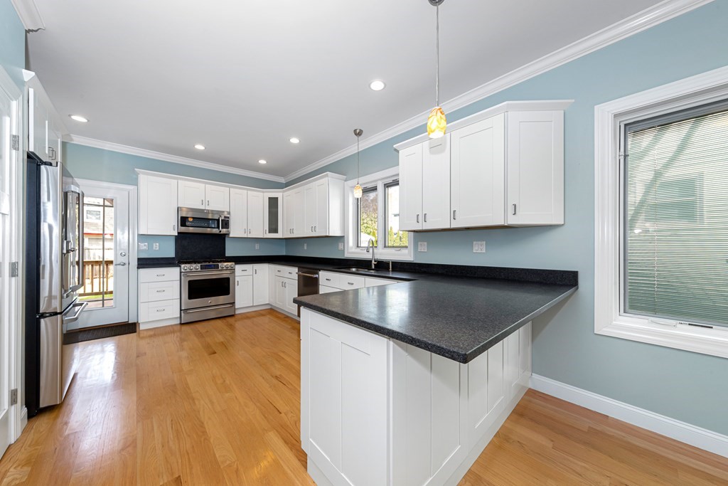 31 Knoll Street Boston, MA 02131 - Photo 11 of 34 a kitchen with kitchen island granite countertop a stove top oven a sink a counter top space and cabinets