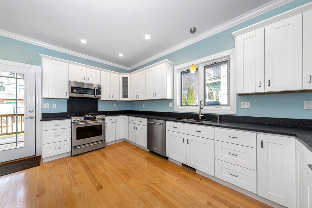 31 Knoll Street Boston, MA 02131 - Photo 12 of 34 a kitchen with granite countertop white cabinets and stainless steel appliances