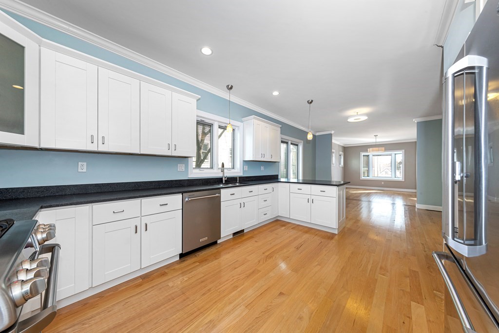 31 Knoll Street Boston, MA 02131 - Photo 13 of 34 a large kitchen with cabinets wooden floor and stainless steel appliances