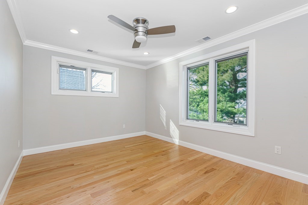 31 Knoll Street Boston, MA 02131 - Photo 27 of 34 a view of a big room with wooden floor a ceiling fan and windows