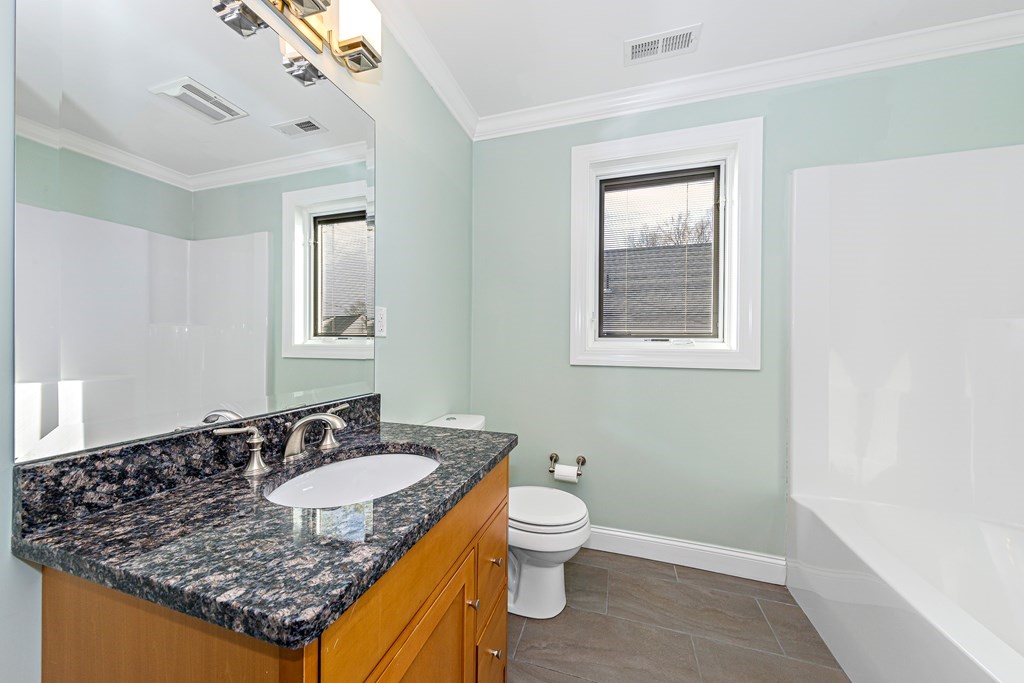 31 Knoll Street Boston, MA 02131 - Photo 30 of 34 a bathroom with a granite countertop sink a toilet and mirror