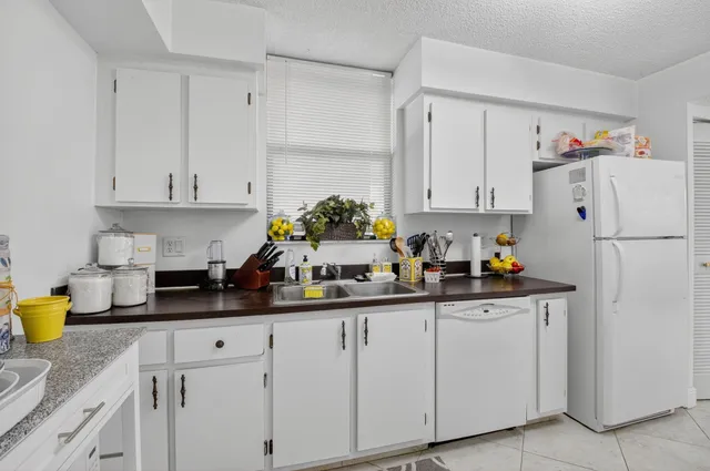 a kitchen with white cabinets and a refrigerator