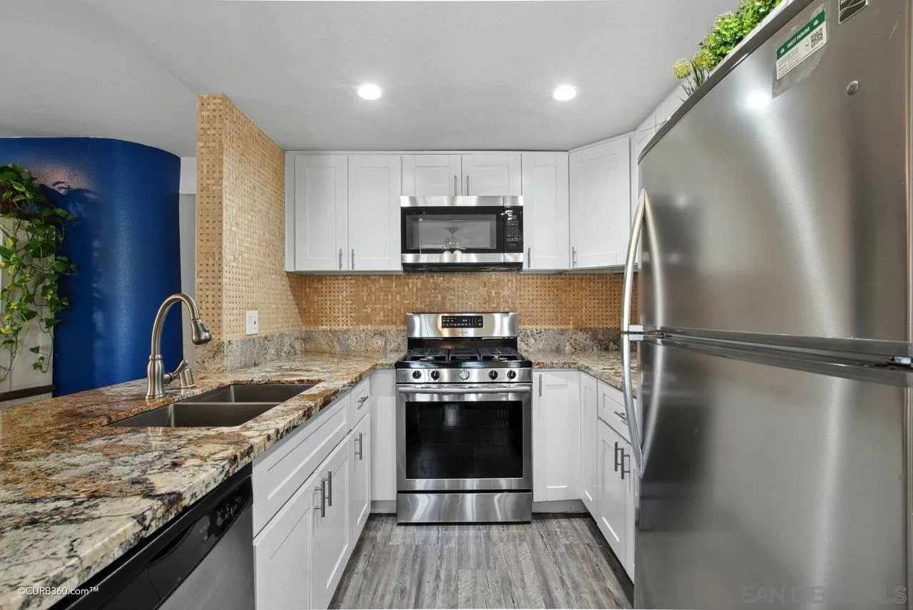 725 Brookstone Road Chula Vista, CA 91913 - Photo 8 of 30 a kitchen with granite countertop a refrigerator a sink a stove and cabinets