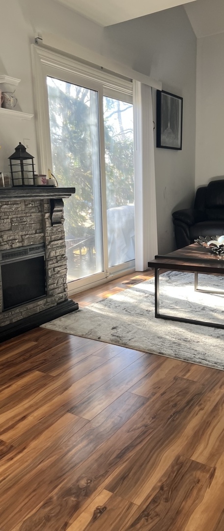 Undisclosed Address Schaumburg, IL 60173 - Photo 3 of 8 a view of an empty room with wooden floor and a fireplace