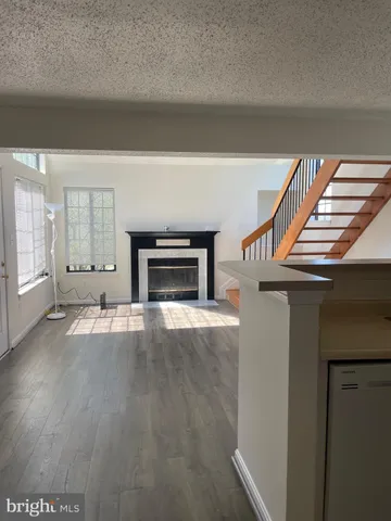 an empty room with a fireplace and wooden floor