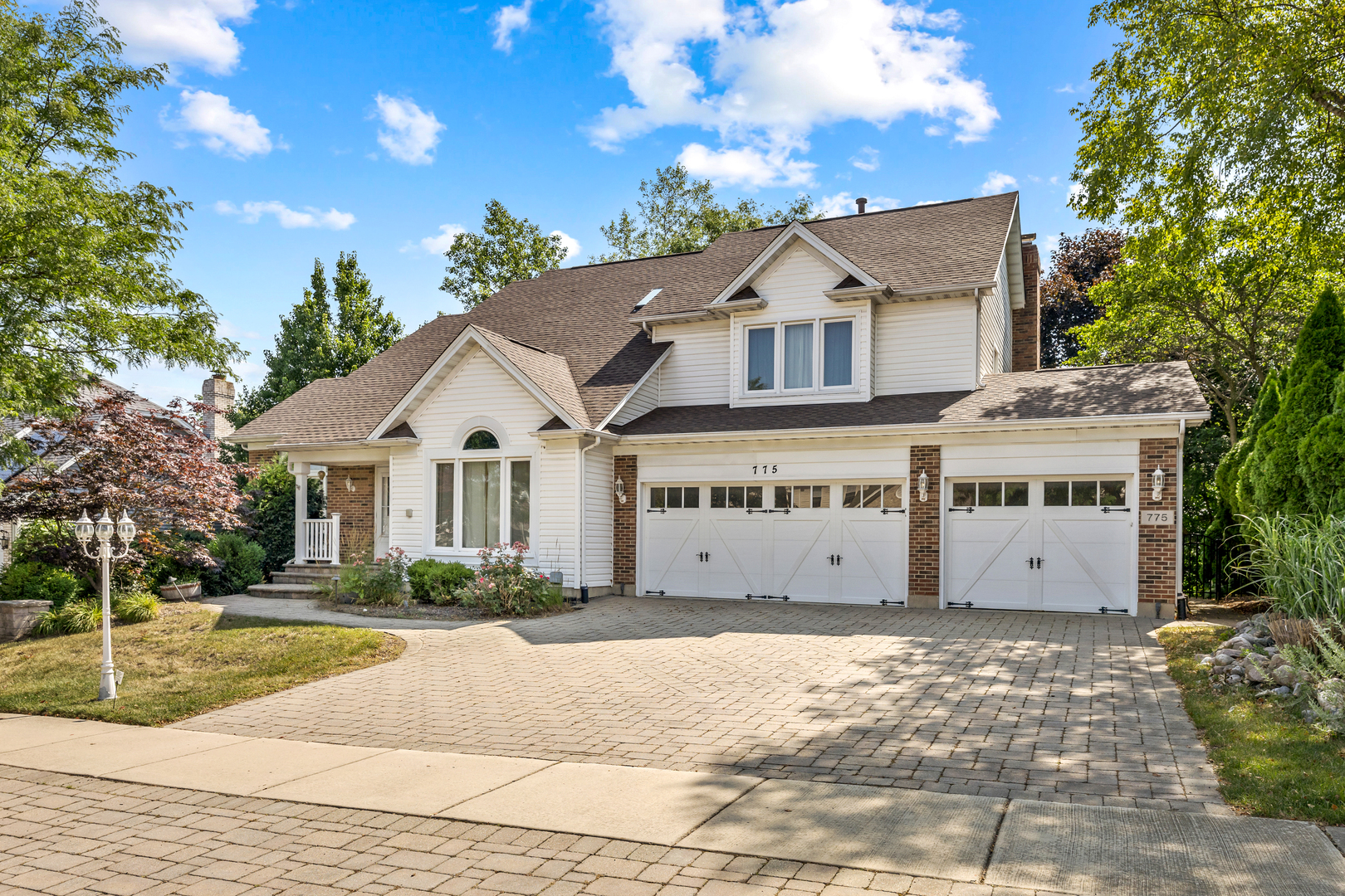 a view of a white house with a large yard and large tree