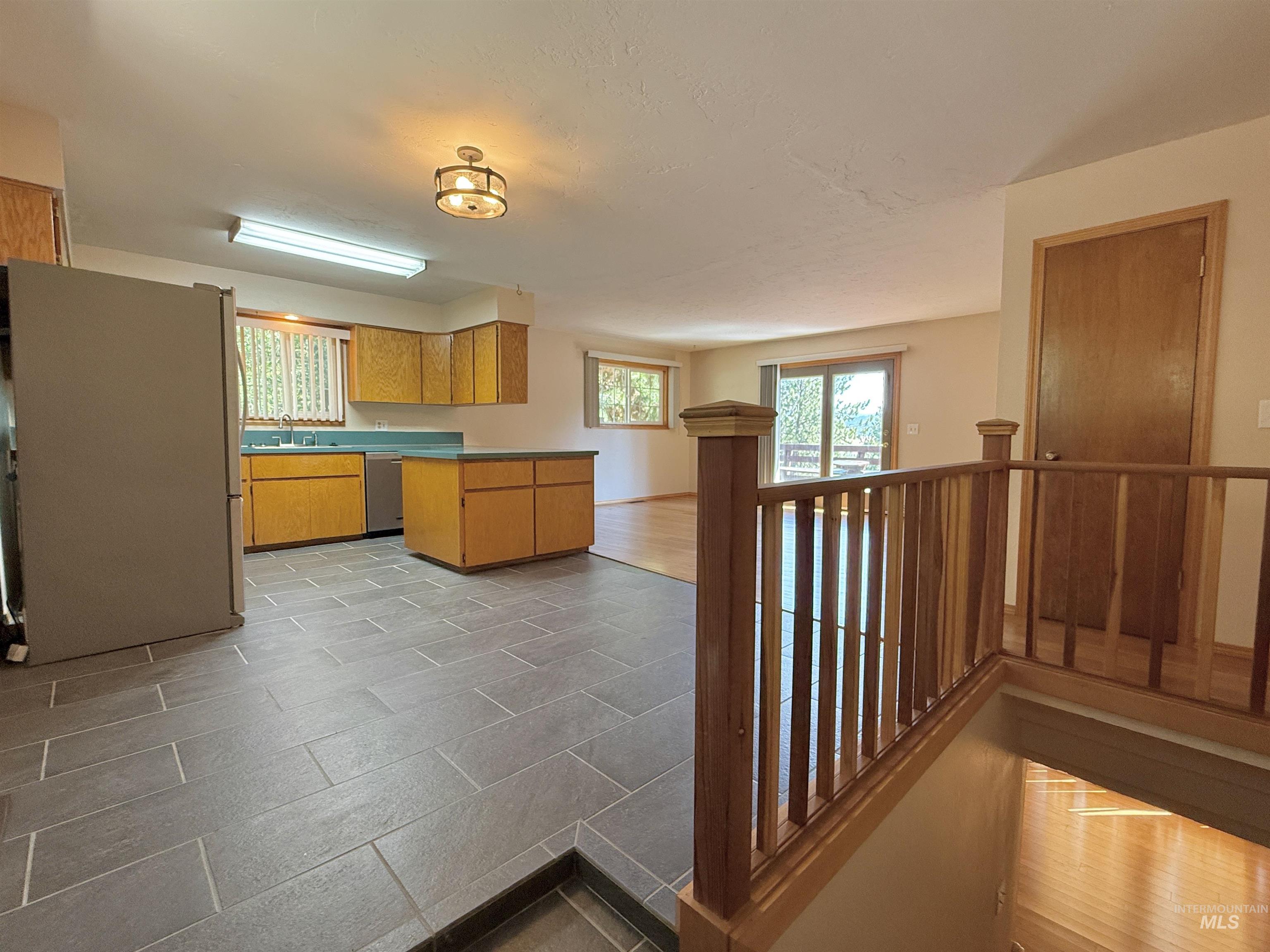 752 Mt Idaho Grade Road Grangeville, ID 83530 - Photo 2 of 29 Kitchen featuring freestanding refrigerator, healthy amount of natural light, dishwasher, and a peninsula